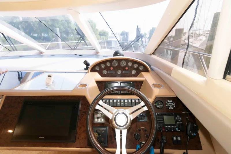 Slide: The Image of Helm of 2003 Princess 50 yacht with steering wheel, gauges, and navigation equipment. - 19