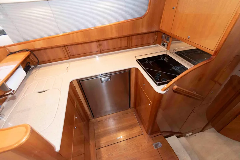 Slide: The Image of Luxurious 2003 Princess 50 yacht kitchen with modern appliances and elegant wood cabinetry. - 25