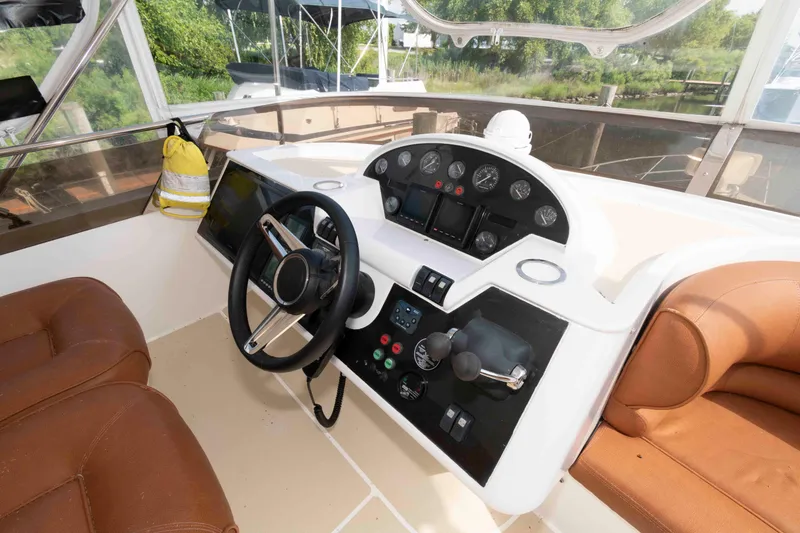 Slide: The Image of Helm of 2003 Princess 50 yacht with brown seating and control panel. - 11