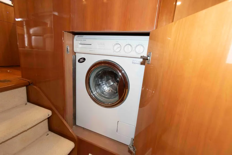Slide: The Image of Built-in washing machine on a 2003 Princess 50 yacht, wooden cabinetry, near carpeted stairs. - 31