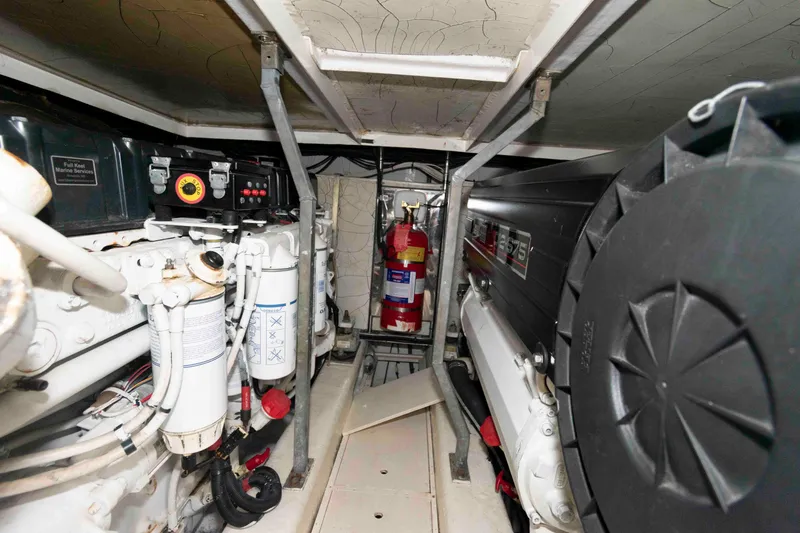 Slide: The Image of Engine room of a 2003 Princess 50 yacht, featuring machinery and fire extinguisher. - 32