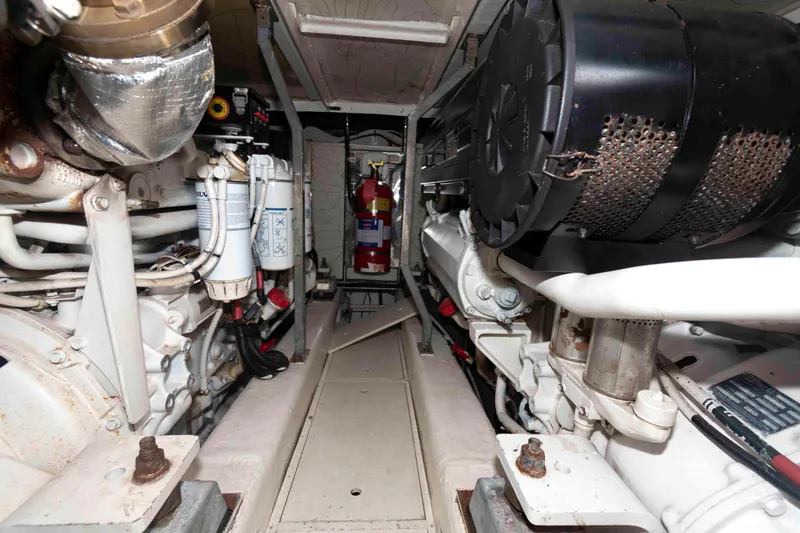 Slide: The Image of Engine room of a 2003 Princess 50 yacht, featuring mechanical components and fire extinguisher. - 35