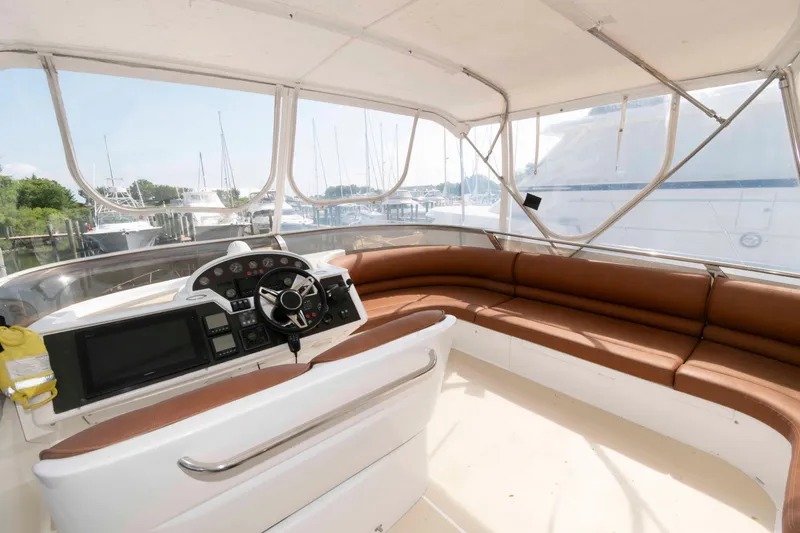 Slide: The Image of Luxurious 2003 Princess 50 yacht interior with helm and brown seating, docked at marina. - 8