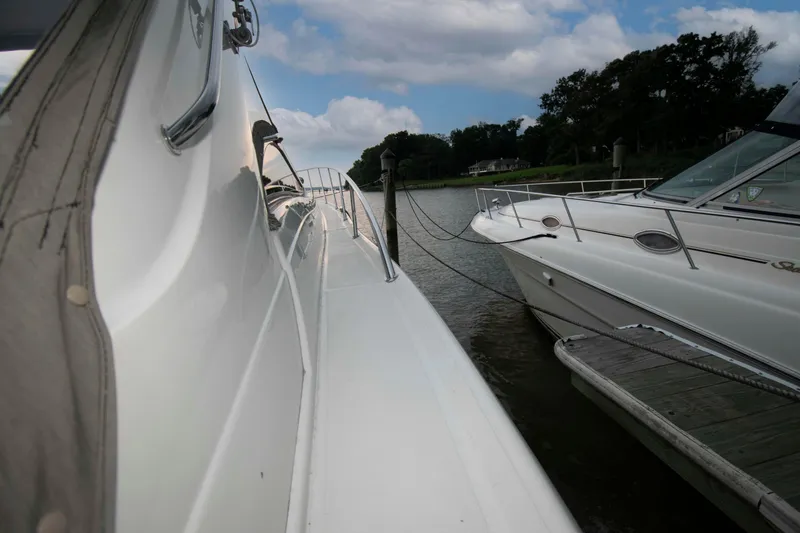 Slide: The Image of 2003 Regal Commodore 4260 yacht docked beside another boat on a calm waterway. - 12