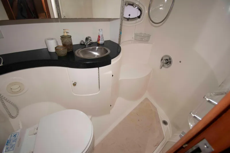 Slide: The Image of Compact bathroom in a 2003 Regal Commodore 4260 yacht, featuring sink, toilet, and shower. - 19