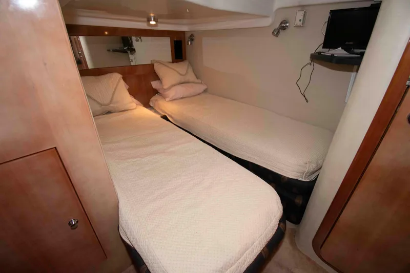 Slide: The Image of 2003 Regal Commodore 4260 cabin with twin beds and compact TV setup. - 20
