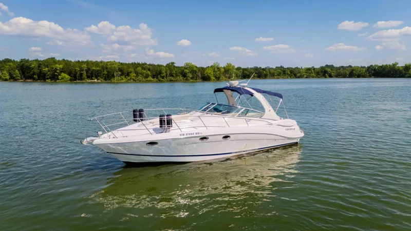 Slide: The Image of 2006 Four Winns 348 Vista boat on a serene lake under a clear blue sky. - 11