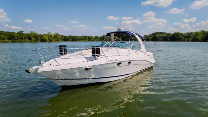 Slide: The Image of 2006 Four Winns 348 Vista boat on a serene lake under a blue sky. - 12