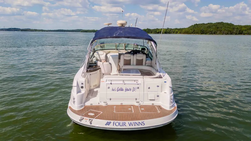 Slide: The Image of 2006 Four Winns 348 Vista boat on calm water, blue canopy, clear sky. - 14