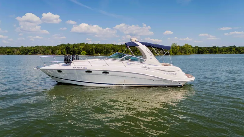 Slide: The Image of 2006 Four Winns 348 Vista boat on a serene lake under a clear blue sky. - 15