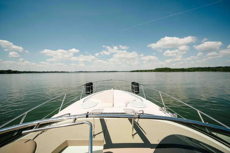 Slide: The Image of Bow view of 2006 Four Winns 348 Vista yacht on a serene lake under blue skies. - 16