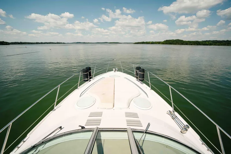 Slide: The Image of Bow view of 2006 Four Winns 348 Vista yacht on a calm lake under a blue sky. - 17