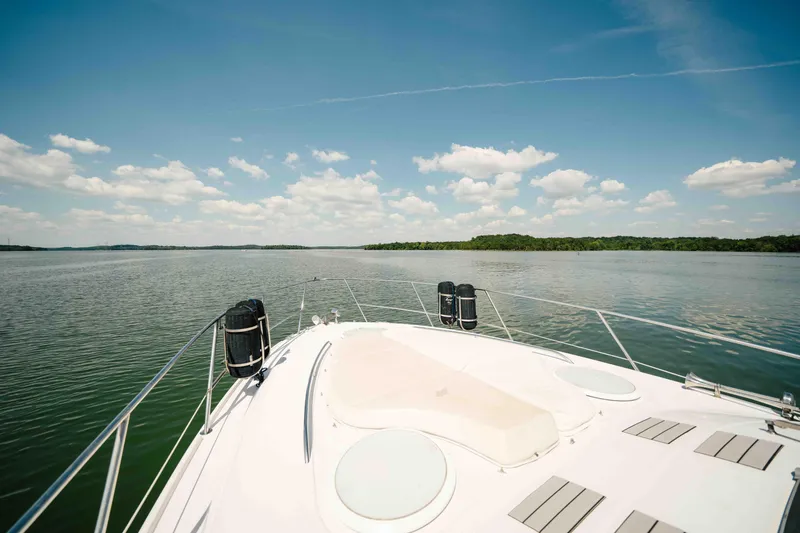 Slide: The Image of 2006 Four Winns 348 Vista yacht cruising on a serene lake under a clear blue sky. - 19