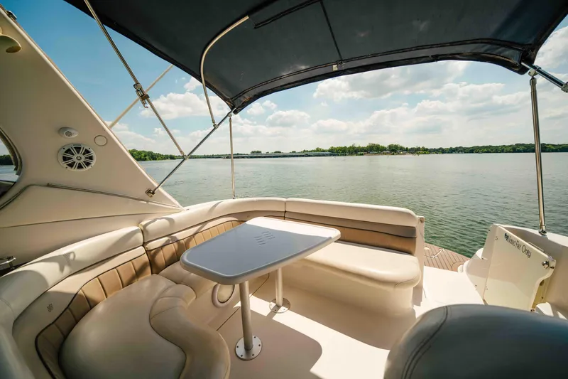 Slide: The Image of 2006 Four Winns 348 Vista boat interior with seating and table, overlooking a serene lake. - 20