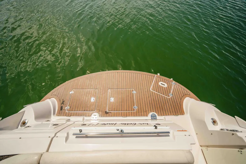 Slide: The Image of 2006 Four Winns 348 Vista boat deck with wooden finish, overlooking green water. - 24