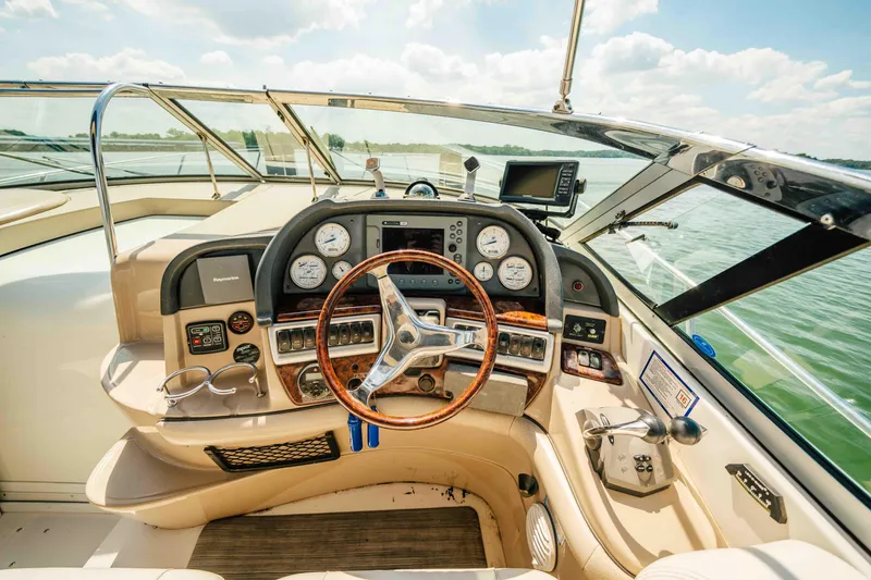 Slide: The Image of 2006 Four Winns 348 Vista boat cockpit with steering wheel and control panel on a sunny day. - 31