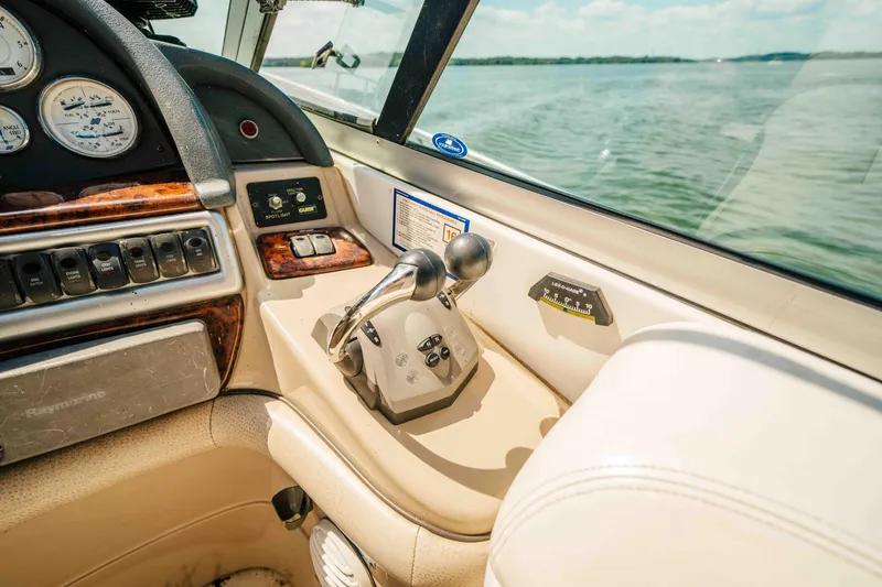 Slide: The Image of 2006 Four Winns 348 Vista boat cockpit with controls and gauges, overlooking water. - 33