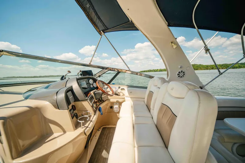 Slide: The Image of 2006 Four Winns 348 Vista boat interior with steering wheel and seating, under blue sky. - 37