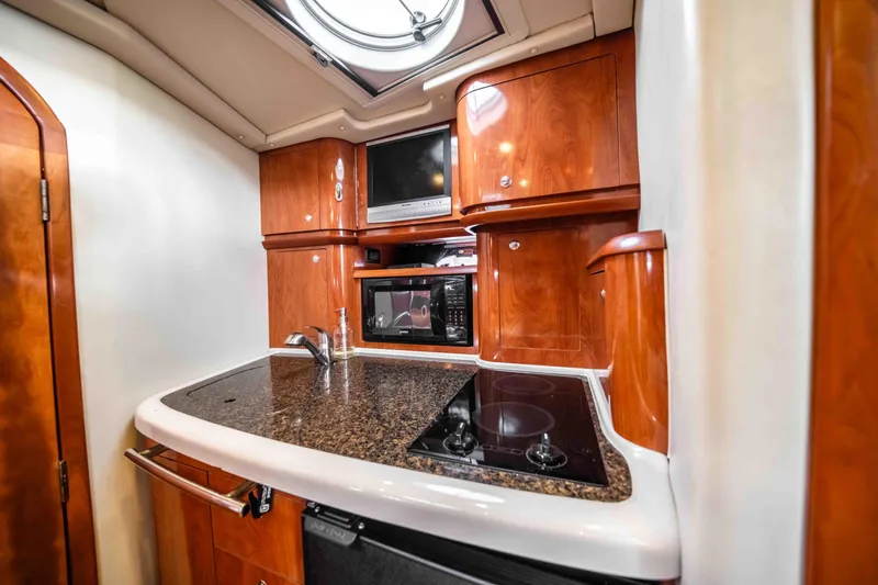 Slide: The Image of Luxurious 2006 Four Winns 348 Vista yacht kitchen with wood cabinetry and modern appliances. - 43