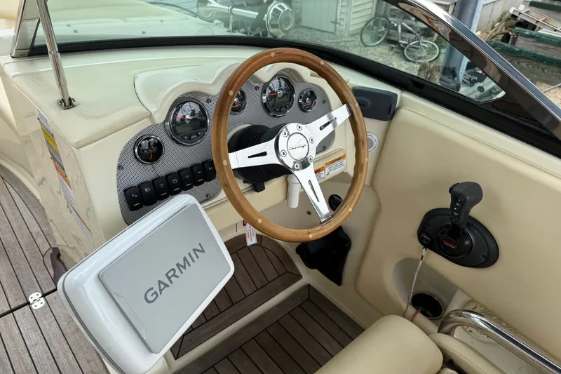 Slide: The Image of 2016 Chris-Craft Launch 22 dashboard with Garmin navigation, wooden steering wheel, and control panel. - 6