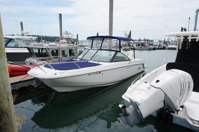 The Image of 2018 Boston Whaler 230 Vantage boat docked at marina, featuring blue canopy and outboard motor. - 0