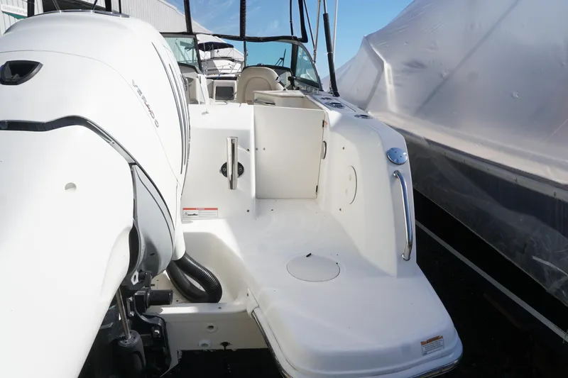 Slide: The Image of 2018 Boston Whaler 230 Vantage boat with outboard motor, docked and covered. - 14