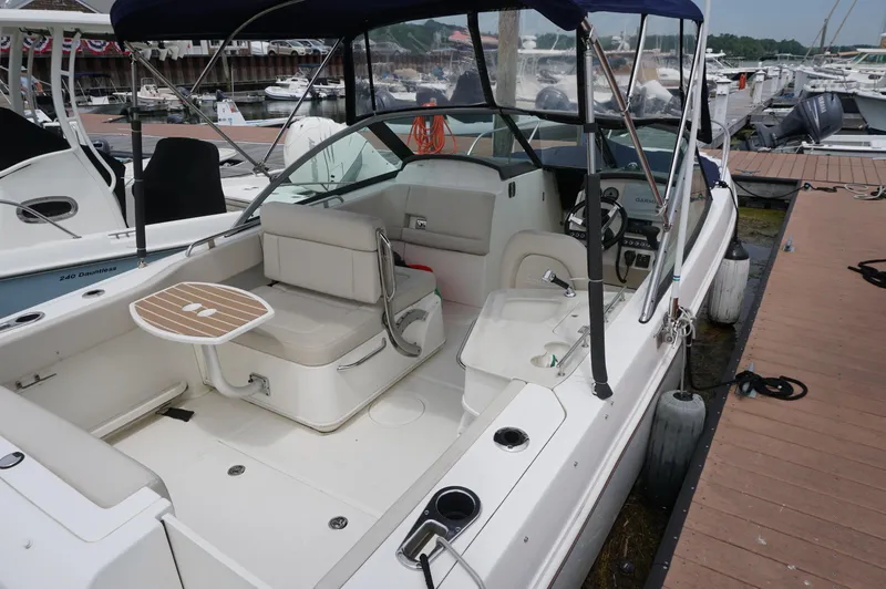 Slide: The Image of 2018 Boston Whaler 230 Vantage boat docked, featuring spacious seating and canopy. - 3