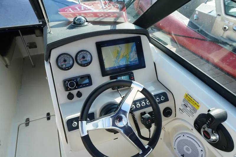 Slide: The Image of 2018 Boston Whaler 230 Vantage dashboard with steering wheel, gauges, and navigation screen. - 8