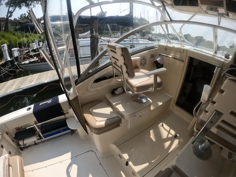 Slide: The Image of 2010 Scout 262 Abaco boat interior with seating and helm at marina. - 11