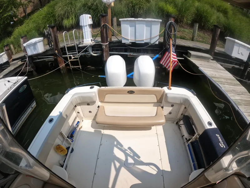 Slide: The Image of 2010 Scout 262 Abaco boat docked, featuring dual engines and American flag. - 12
