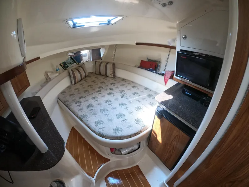 Slide: The Image of 2010 Scout 262 Abaco cabin interior with bed, TV, and wood accents. - 14