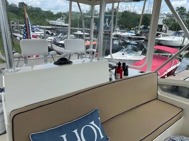 Slide: The Image of 1986 Viking 35 Convertible yacht interior with marina view, featuring seating and nautical decor. - 14