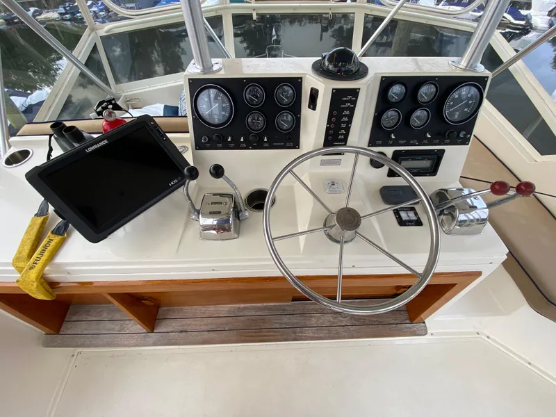 Slide: The Image of 1986 Viking 35 Convertible boat helm with steering wheel, gauges, and navigation equipment. - 15