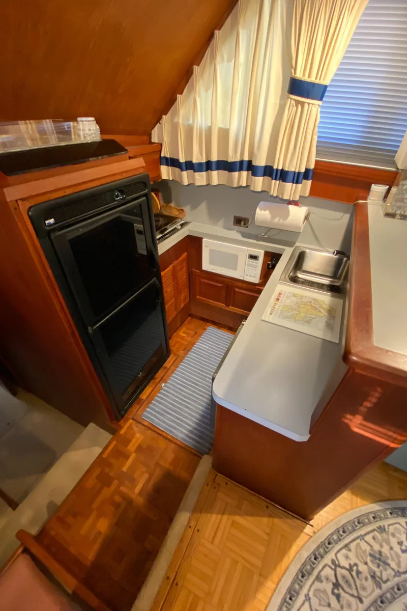 Slide: The Image of Compact kitchen in 1986 Viking 35 Convertible boat with wood cabinetry and modern appliances. - 27