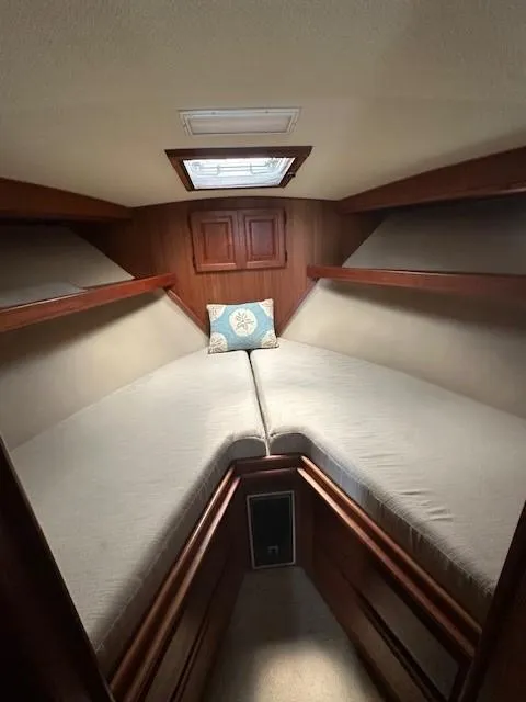Slide: The Image of 1986 Viking 35 Convertible cabin interior with cozy V-berth and wooden accents. - 29
