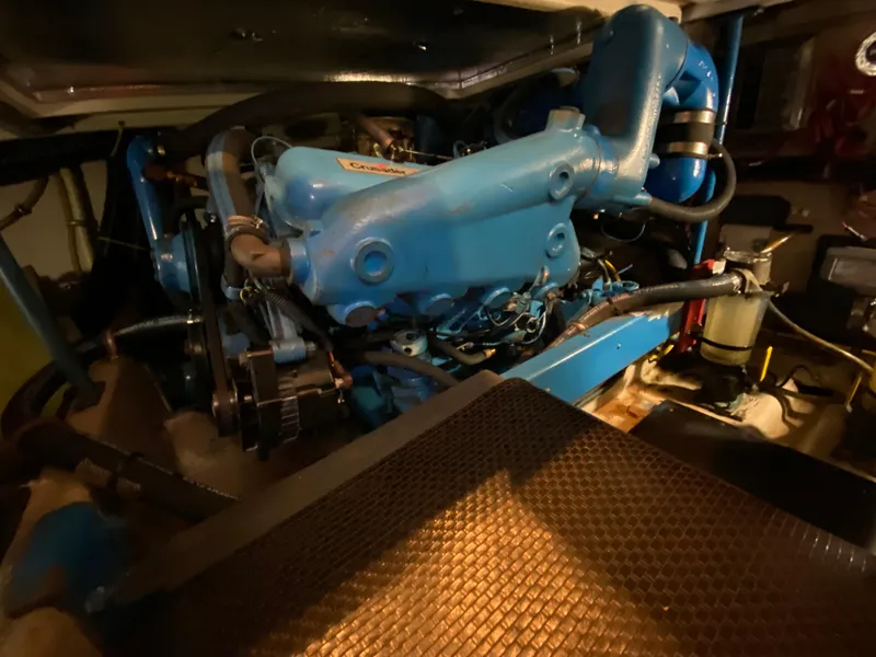Slide: The Image of Engine compartment of a 1986 Viking 35 Convertible boat, featuring a blue Crusader engine. - 33