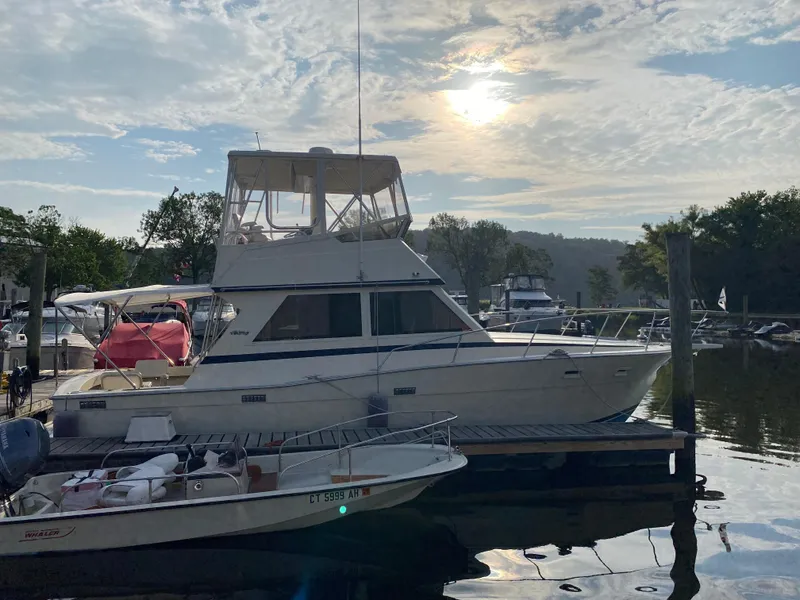 Slide: The Image of 1986 Viking 35 Convertible yacht docked at marina under cloudy sky. - 5