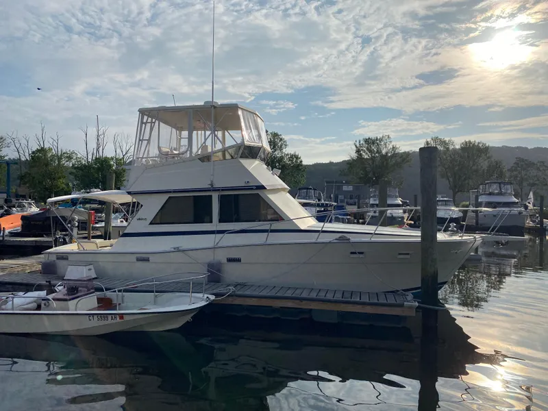 Slide: The Image of 1986 Viking 35 Convertible yacht docked at marina under a partly cloudy sky. - 7