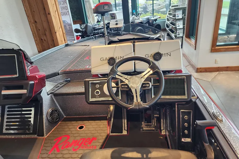 Slide: The Image of 2025 Ranger Z521R Cup-Equipped boat dashboard with Garmin displays and steering wheel. - 1