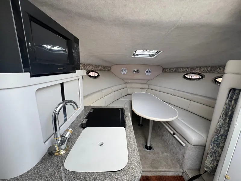 Slide: The Image of Interior of 2000 Crownline 242 CR boat with kitchenette and seating area. - 13