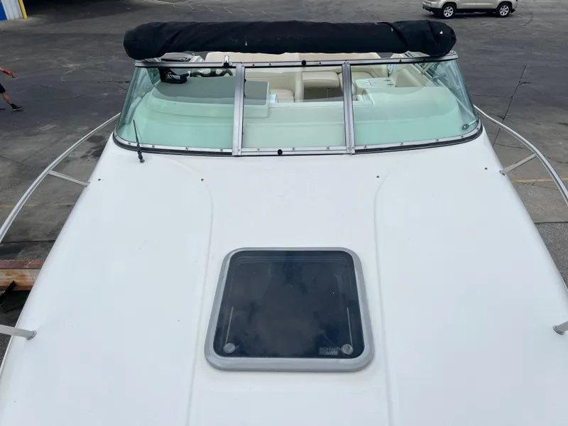 Slide: The Image of 2000 Crownline 242 CR boat with windshield and hatch, docked on concrete surface. - 18