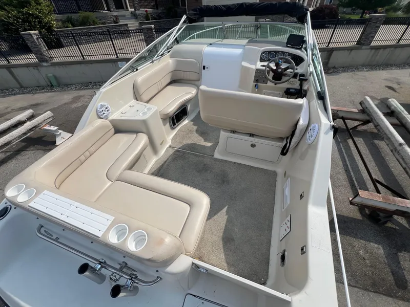 Slide: The Image of 2000 Crownline 242 CR boat interior with beige seating and steering console. - 6