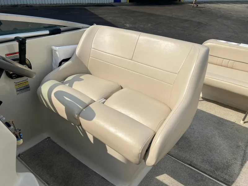 Slide: The Image of Crownline 242 CR 2000 boat interior with beige captain's seat and steering wheel. - 9