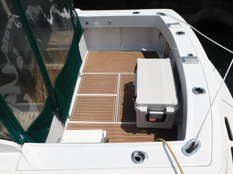 Slide: The Image of 1999 Mainship Pilot 30 boat deck with cooler and green canopy. - 10