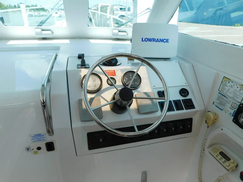 Slide: The Image of 1999 Mainship Pilot 30 helm with steering wheel and navigation equipment. - 20