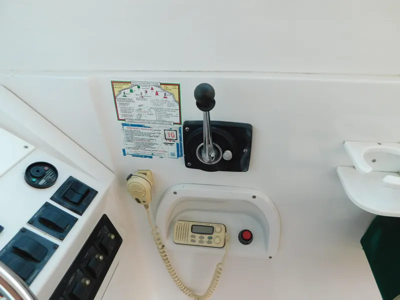 Slide: The Image of 1999 Mainship Pilot 30 control panel with throttle, radio, and switches. - 21