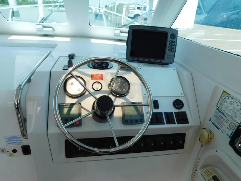 Slide: The Image of 1999 Mainship Pilot 30 helm with steering wheel, gauges, and navigation equipment. - 22