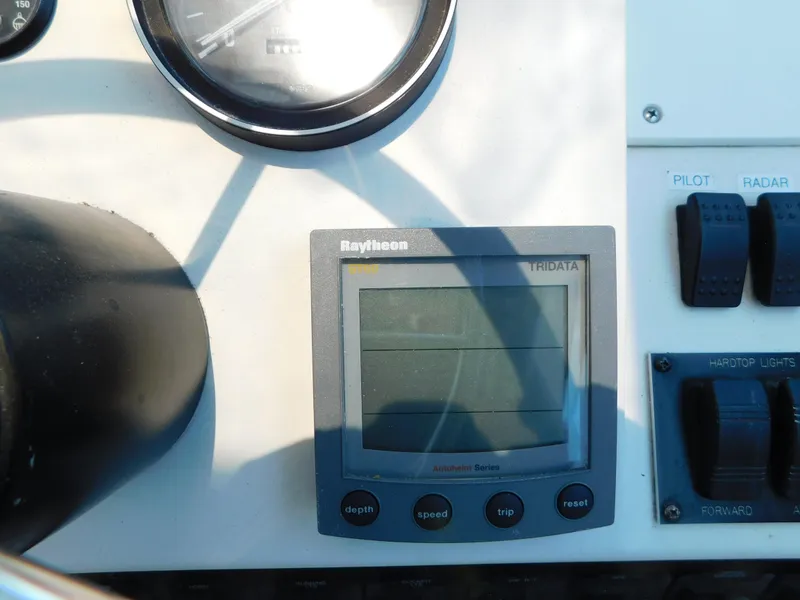 Slide: The Image of 1999 Mainship Pilot 30 dashboard with Raytheon Tridata display and control switches. - 24