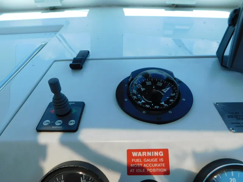 Slide: The Image of Control panel of a 1999 Mainship Pilot 30 boat with compass and warning label. - 25