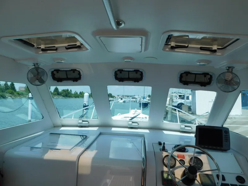 Slide: The Image of Interior view of 1999 Mainship Pilot 30 boat cockpit with steering wheel and navigation equipment. - 28